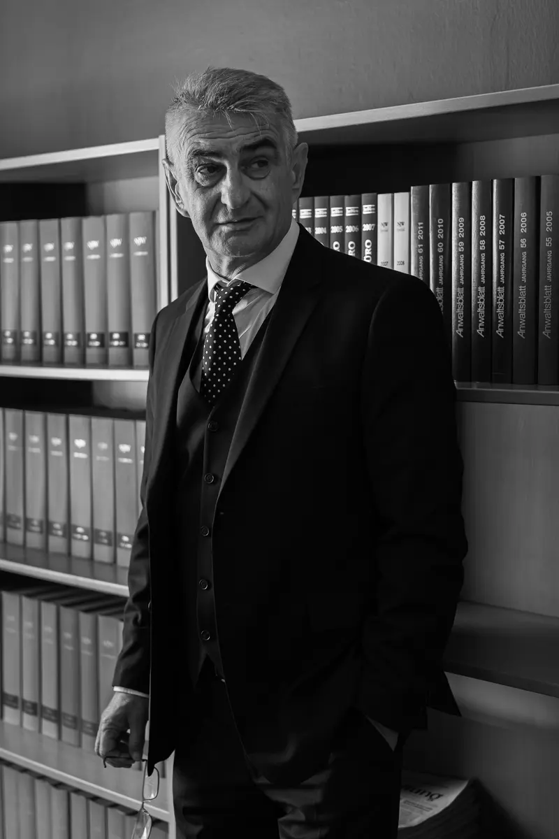Helmut Mörtl steht vor einem Regal mit Akten, schwarzweiß